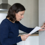 Femme lisant un document près d'un mur
