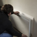 Homme installant un radiateur mural blanc