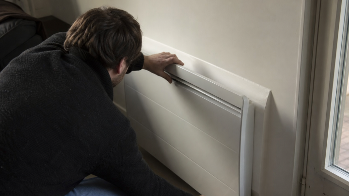 Homme installant un radiateur mural blanc